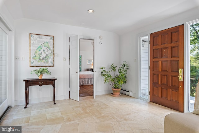 foyer entrance with a baseboard heating unit