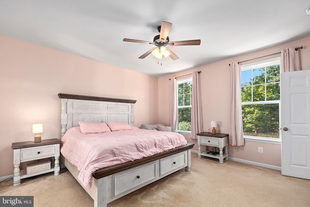 carpeted bedroom featuring ceiling fan and multiple windows