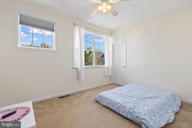 bedroom with light carpet and ceiling fan