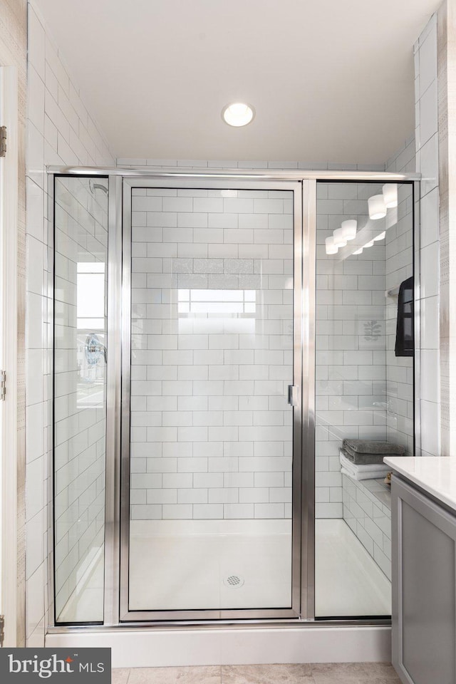 bathroom featuring tile patterned floors, vanity, and a shower with shower door