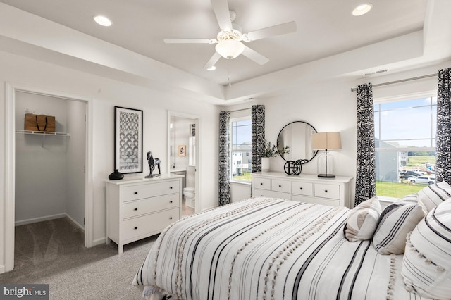 carpeted bedroom featuring a spacious closet, a closet, connected bathroom, and multiple windows