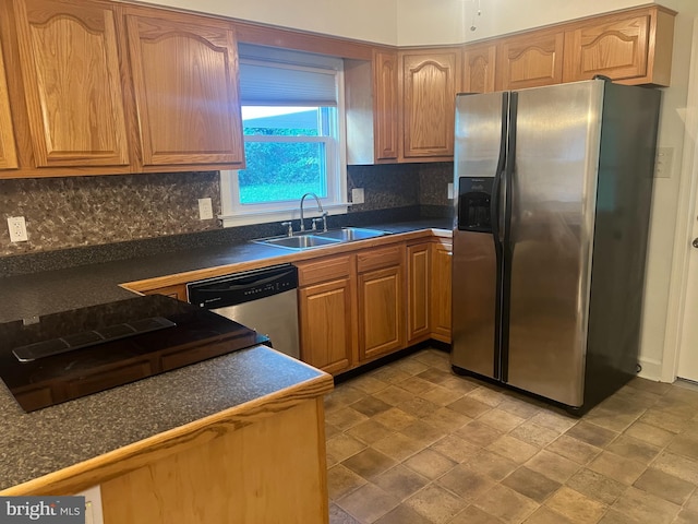 kitchen with tasteful backsplash, appliances with stainless steel finishes, and sink