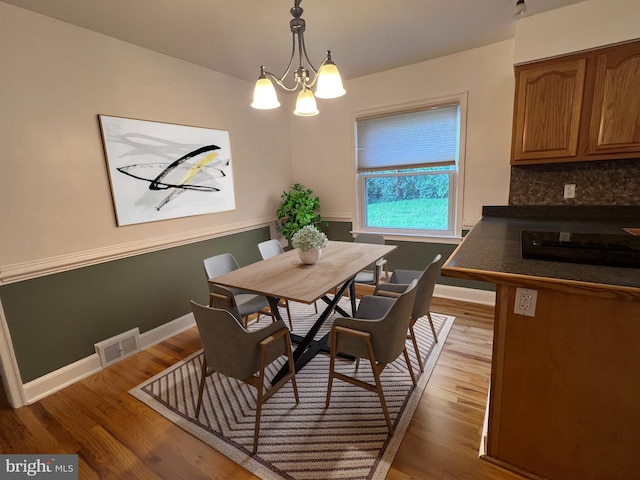 dining room featuring a notable chandelier and wood-type flooring