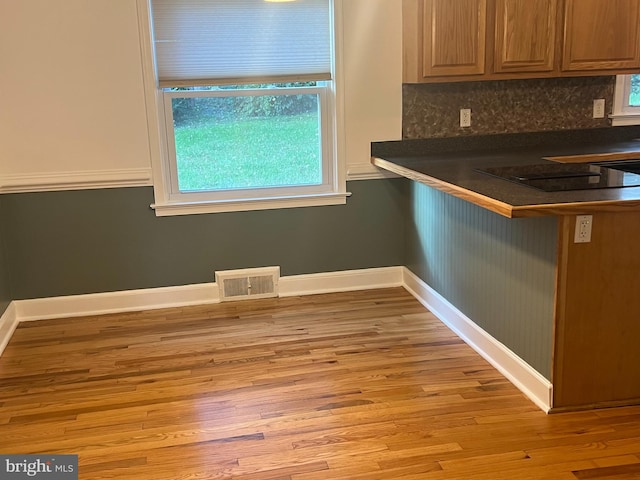 kitchen with light hardwood / wood-style flooring and decorative backsplash