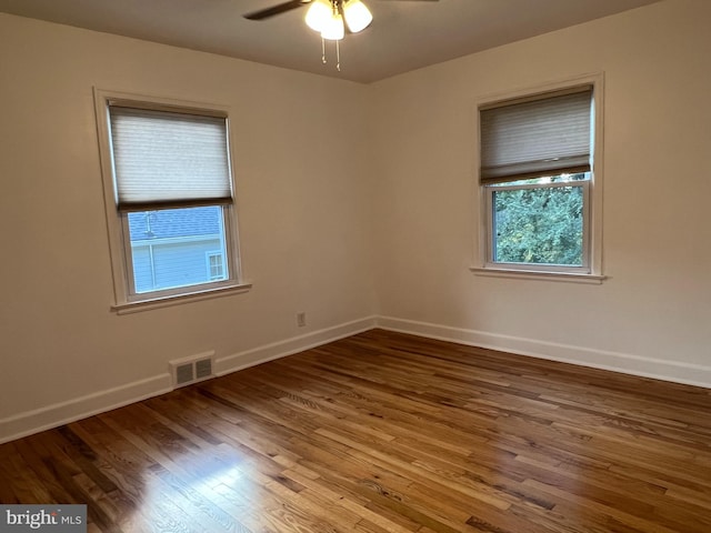 empty room with hardwood / wood-style floors and ceiling fan