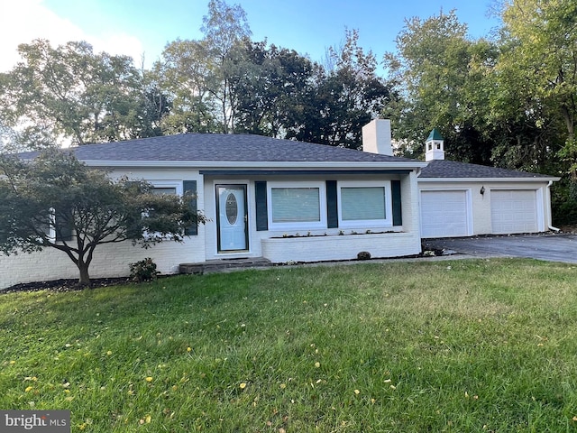 ranch-style house featuring a front lawn and a garage