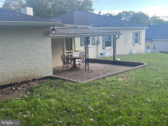 rear view of property featuring a patio and a yard