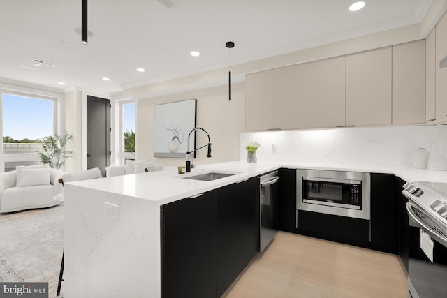 kitchen with appliances with stainless steel finishes, hanging light fixtures, sink, and kitchen peninsula