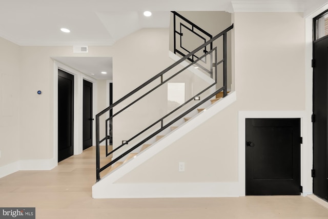 stairway featuring wood-type flooring and ornamental molding