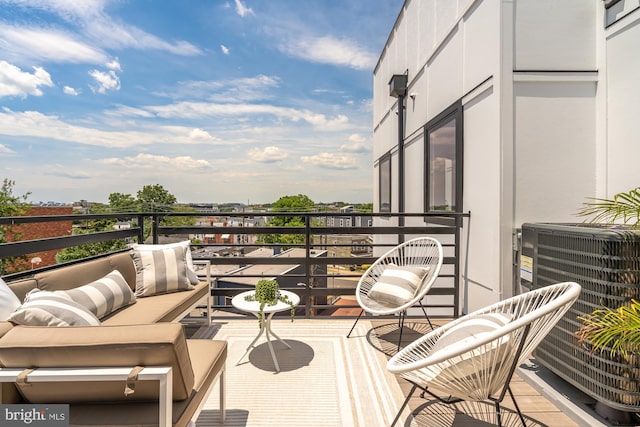 balcony with an outdoor living space and central air condition unit