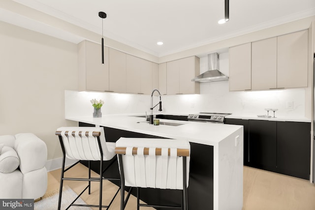 kitchen with wall chimney range hood, decorative light fixtures, sink, stainless steel range with electric stovetop, and a kitchen bar