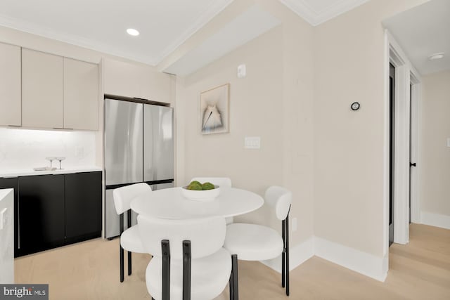 dining room featuring light hardwood / wood-style floors and crown molding