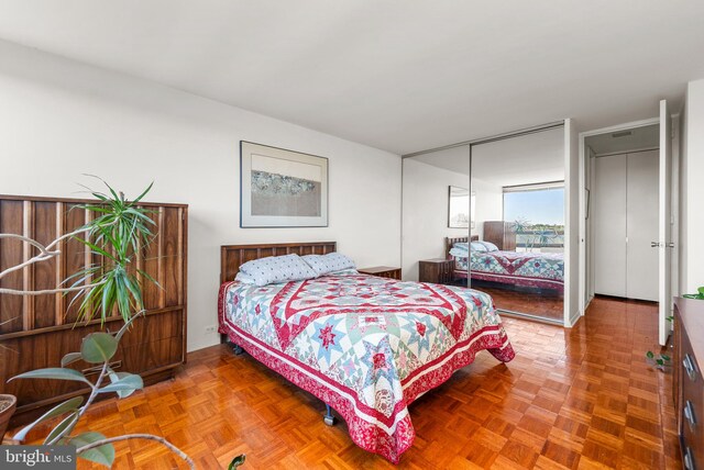 bedroom featuring parquet flooring and a closet