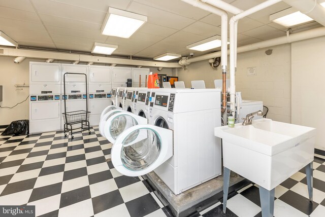 clothes washing area with sink, separate washer and dryer, and stacked washing maching and dryer