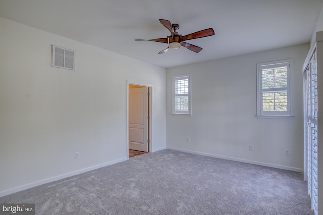 empty room with ceiling fan and light colored carpet