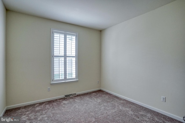 unfurnished room featuring light carpet