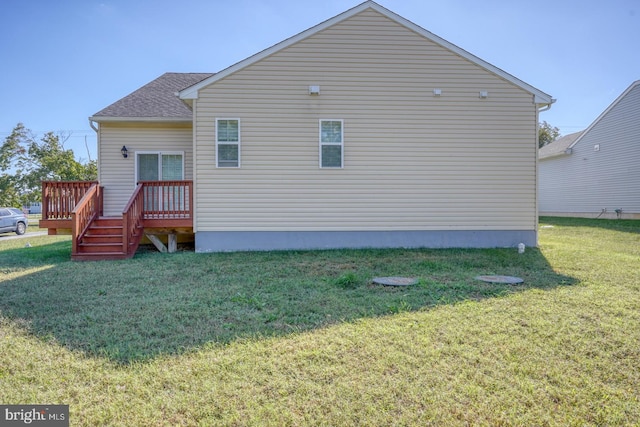 rear view of house featuring a wooden deck and a yard