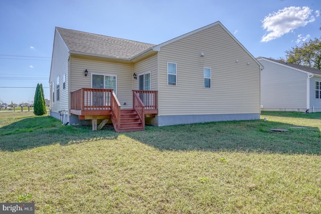 rear view of house featuring a yard and a wooden deck