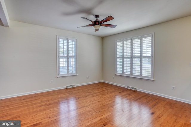 empty room with ceiling fan and light hardwood / wood-style floors