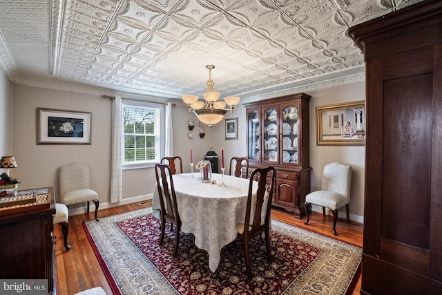 dining space featuring a notable chandelier, crown molding, and dark wood-type flooring