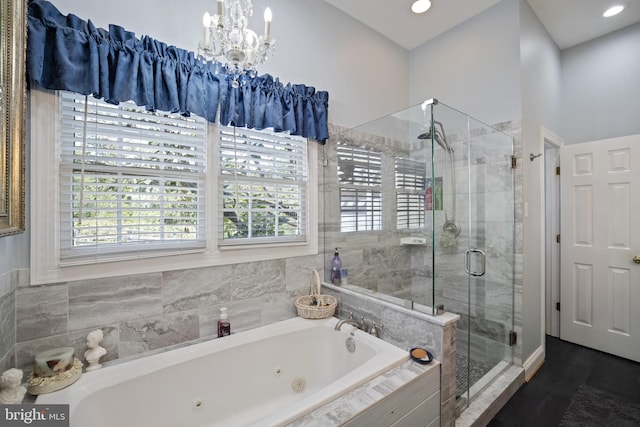 bathroom featuring a shower stall, recessed lighting, a jetted tub, and a notable chandelier