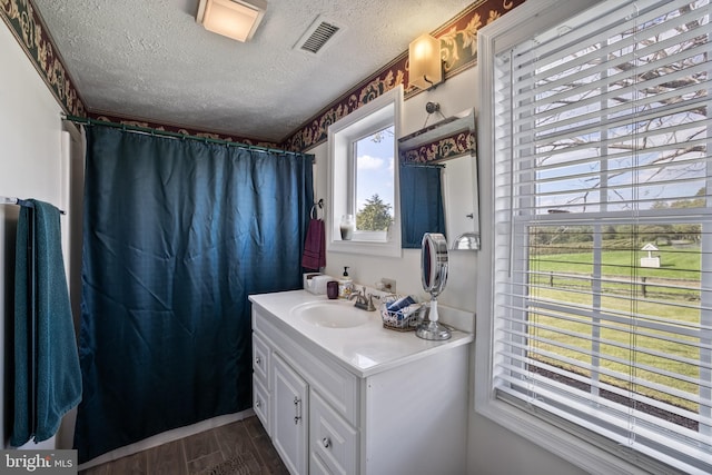 bathroom featuring hardwood / wood-style flooring, a shower with curtain, vanity, and a textured ceiling