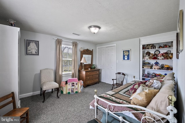 carpeted bedroom with a textured ceiling, a closet, baseboards, and visible vents