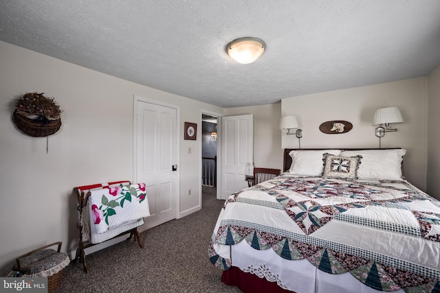 bedroom featuring a textured ceiling and dark colored carpet