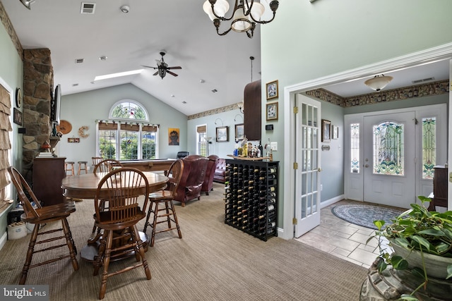 dining space featuring light tile patterned flooring, ceiling fan with notable chandelier, and vaulted ceiling