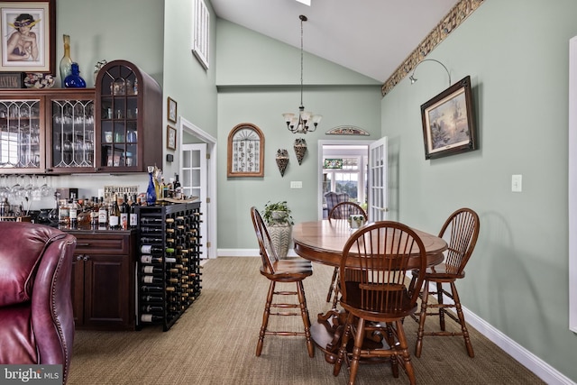 dining room with carpet, high vaulted ceiling, a chandelier, and indoor bar