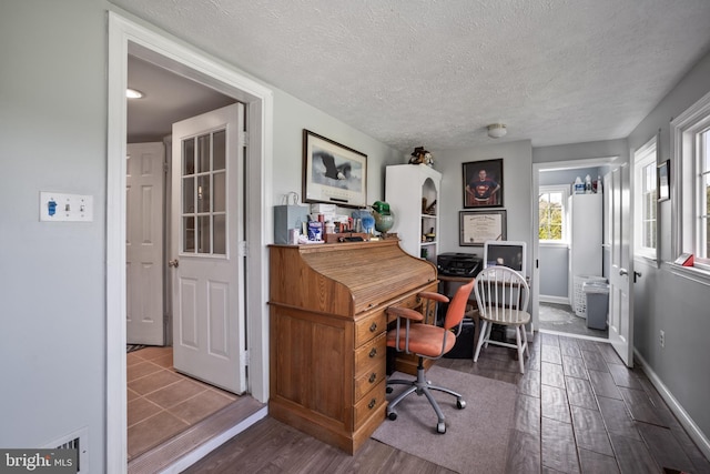 office space featuring dark wood-type flooring, a textured ceiling, and baseboards