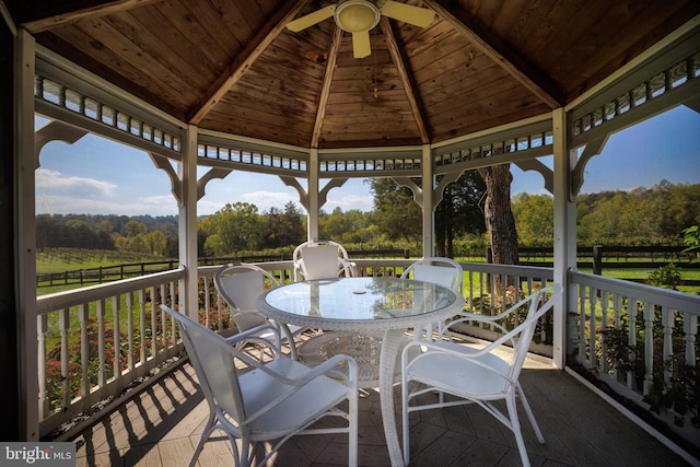 wooden terrace with a gazebo and ceiling fan