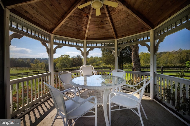 wooden terrace featuring a gazebo and outdoor dining area