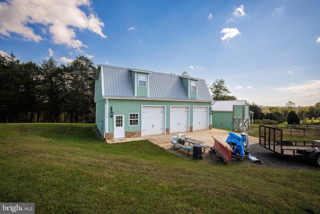 rear view of house with a garage and a yard