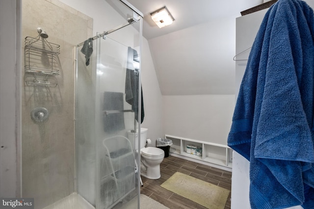 full bath featuring wood finish floors, a stall shower, and toilet