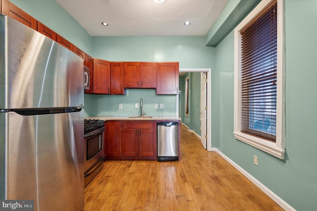 kitchen with light hardwood / wood-style floors, stainless steel appliances, and sink