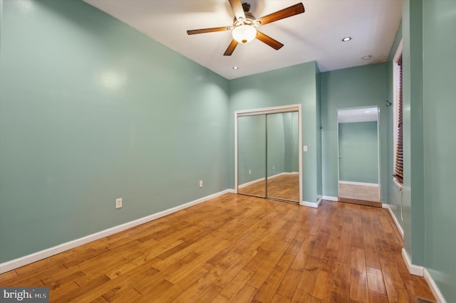 unfurnished bedroom with a closet, light wood-type flooring, and ceiling fan