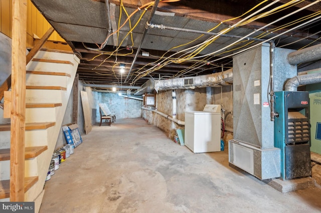 basement featuring washer / clothes dryer, heating unit, and electric panel