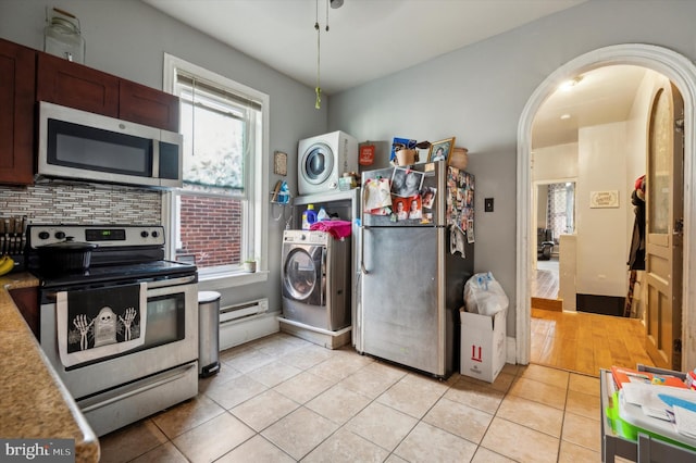 kitchen featuring dark brown cabinetry, light tile patterned flooring, appliances with stainless steel finishes, and decorative backsplash