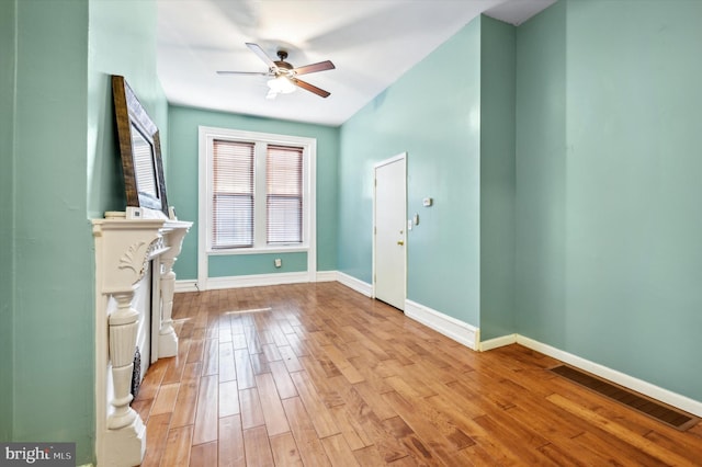 unfurnished living room with a fireplace, ceiling fan, and light hardwood / wood-style floors