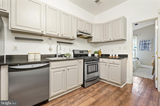 kitchen featuring appliances with stainless steel finishes, sink, and dark hardwood / wood-style flooring