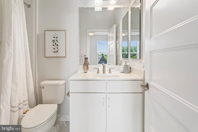 bathroom featuring curtained shower, vanity, and toilet