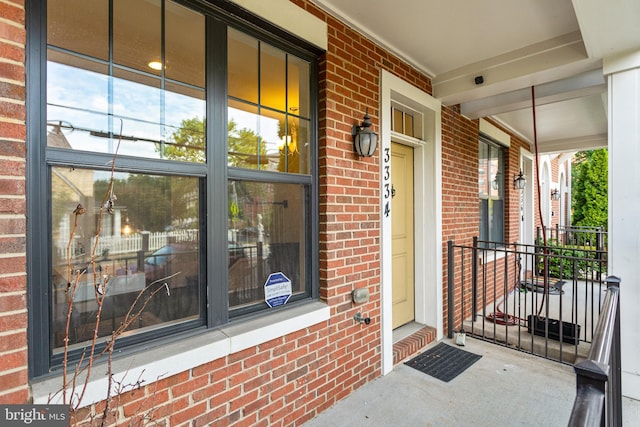 view of exterior entry featuring covered porch