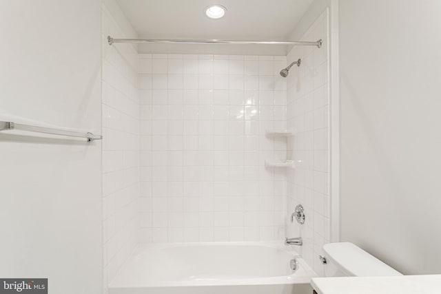 bathroom featuring toilet and tiled shower / bath combo