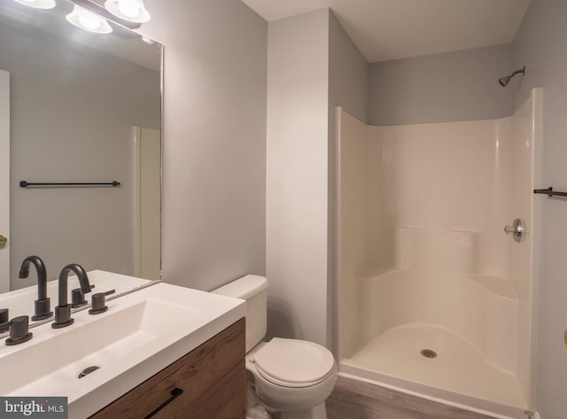 bathroom featuring vanity, toilet, and a shower