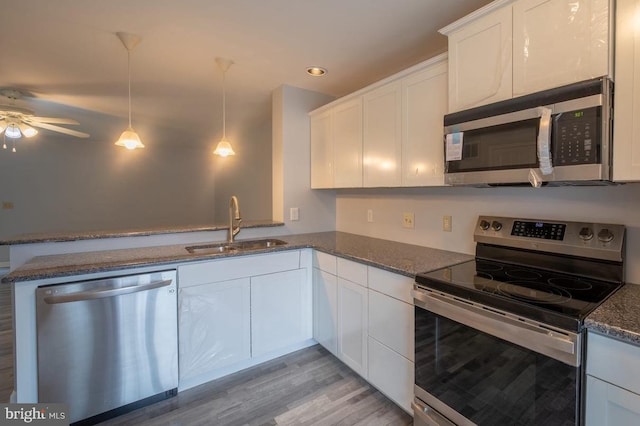 kitchen featuring kitchen peninsula, light wood-type flooring, white cabinetry, and stainless steel appliances