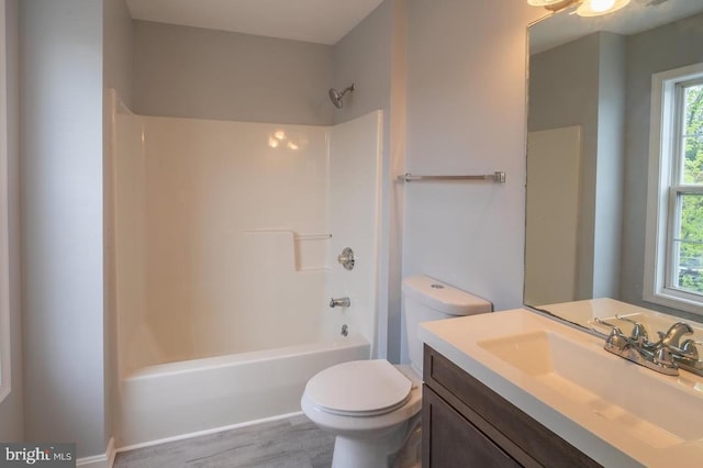 full bathroom with shower / bath combination, hardwood / wood-style floors, vanity, and toilet