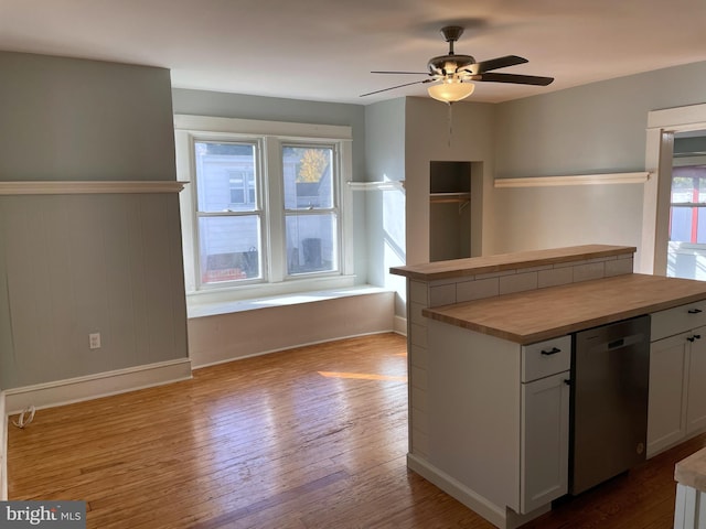 kitchen with wood counters, stainless steel dishwasher, white cabinetry, light hardwood / wood-style floors, and ceiling fan