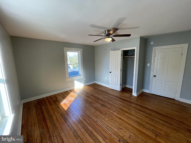 unfurnished bedroom with a closet, dark hardwood / wood-style floors, and ceiling fan