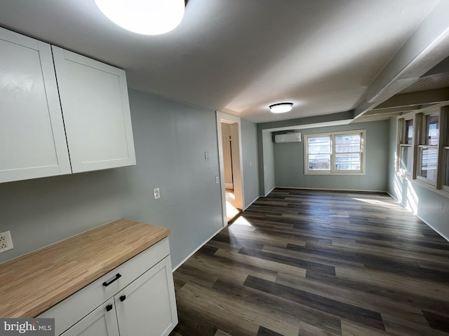 interior space featuring a wall mounted AC and dark hardwood / wood-style flooring